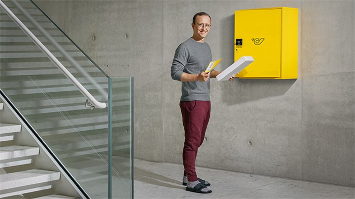 Kund*in nimmt Sendung aus Post Empfangsbox